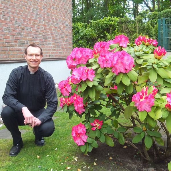 Alter Mann vor einem
      blühenden Strauch - 12.05.2019